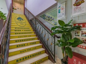 A staircase with yellow steps and a metal railing, leading to a landing with a potted plant. - Greentree Inn Beijing Yuegezhuang Hotel (Beijing)