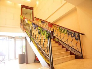Una escalera con barandales de metal ornamentados y decoraciones florales.