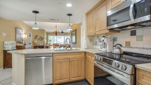 A modern kitchen with wooden cabinets, a stainless steel dishwasher, a built-in oven, a microwave, and a coffee maker. - Palmetto Dunes Ocean-View Villa w/ Balcony, Jacuzzi,  Golf, Dolphin Tour & Beach Gear Included (Hilton Head Island)