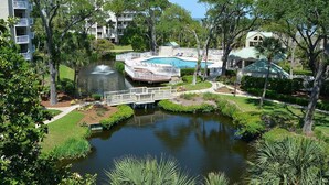 A resort with a swimming pool, a small pond, and lush greenery. - Palmetto Dunes Ocean-View Villa w/ Balcony, Jacuzzi,  Golf, Dolphin Tour & Beach Gear Included (Hilton Head Island)