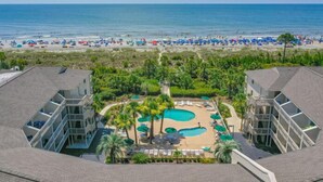 A resort with a pool area, beach access, and modern buildings. - Panoramic Ocean Views! Breakers Condo Steps to Dining & Shops (Hilton Head Island)