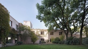 A courtyard with a grassy lawn, trees, and buildings with a modern architectural style. - Shanghai Nanquan Hotel (Lujiazui Tangqiao Metro Station Branch) (Shanghai)