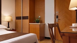 A hotel room with a bed, bedside table, lamp, desk, chair, and a small plant. - Shanghai Nanquan Hotel (Lujiazui Tangqiao Metro Station Branch) (Shanghai)