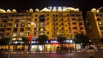 A multi-story hotel with illuminated signage and balconies.
