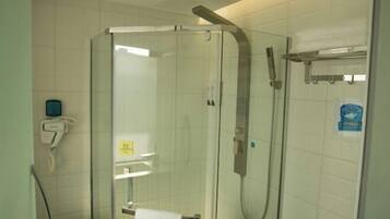 A glass-enclosed shower stall with a handheld showerhead and a towel rack.