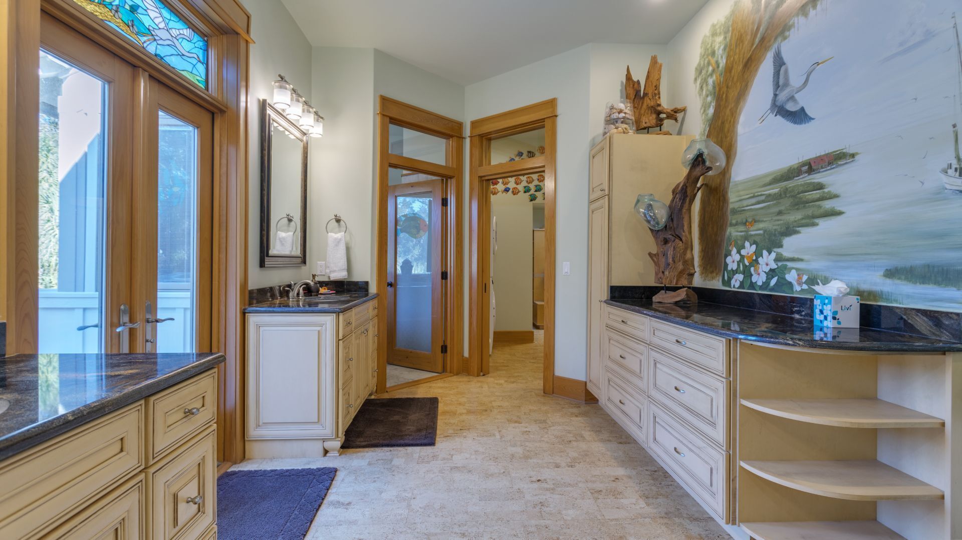 A spacious bathroom with a large vanity, a mirror, and a decorative wall mural.