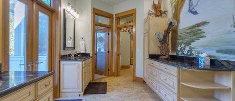 A spacious bathroom with a large vanity, a mirror, and a decorative wall mural.