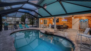 A swimming pool with lounge chairs and a covered patio area. - Private Screened Pool-Balcony with Views-Pet Friendly-The Lazy Place✨ (Fort Myers Beach)