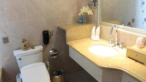 A bathroom with a toilet, bidet, sink, and mirror. - Jinling Huifu Hotel (Yangzhou)