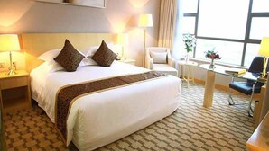 A hotel room with a large bed, two bedside tables with lamps, a small round table with a chair, and a large window providing a view. - Jinling Huifu Hotel (Yangzhou)