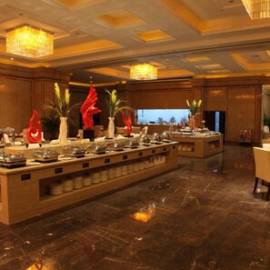 A buffet setup with multiple serving stations, a marble floor, and decorative vases. - Jinling Huifu Hotel (Yangzhou)