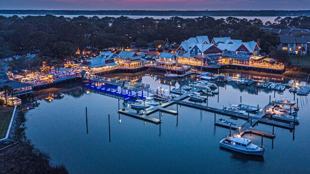 A waterfront property with multiple buildings, a dock, and boats.