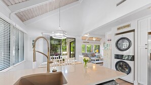A kitchen with a built-in dishwasher, a sink, and a washing machine.