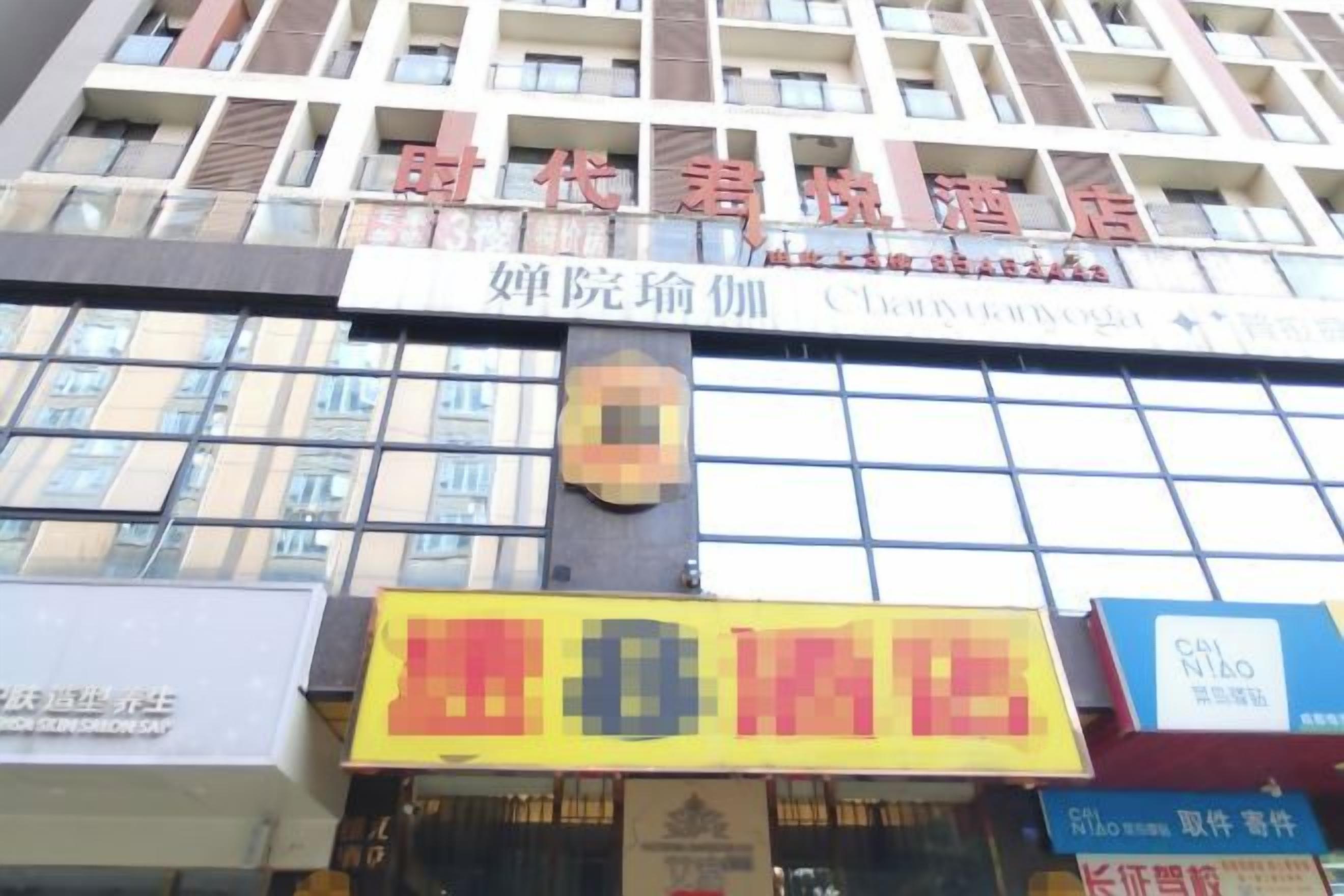 A hotel with multiple floors, a prominent sign for a restaurant, and a digital display.