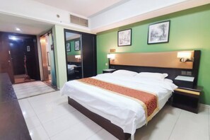 A hotel room with a bed, bedside tables, a mirror, and artwork on the walls.