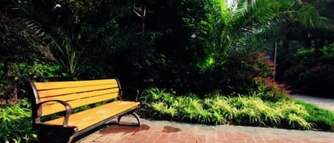 A bench in a landscaped area with a brick pathway.