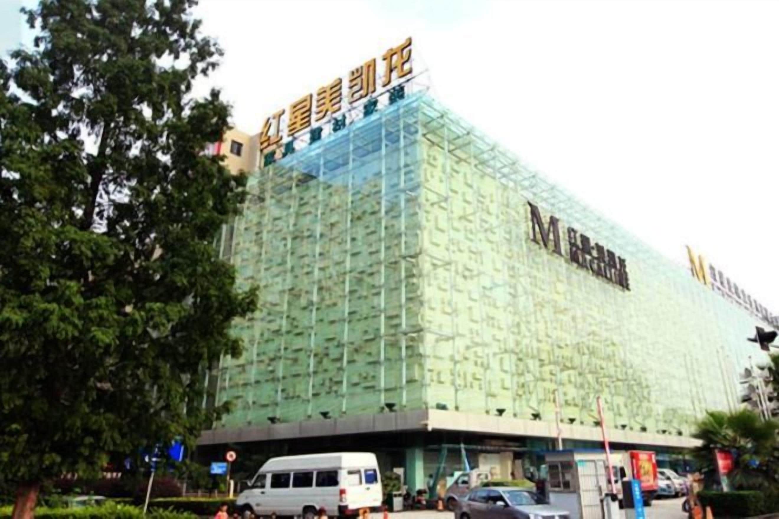 A large building with a distinctive facade, possibly a hotel or commercial complex, with a prominent sign at the top.