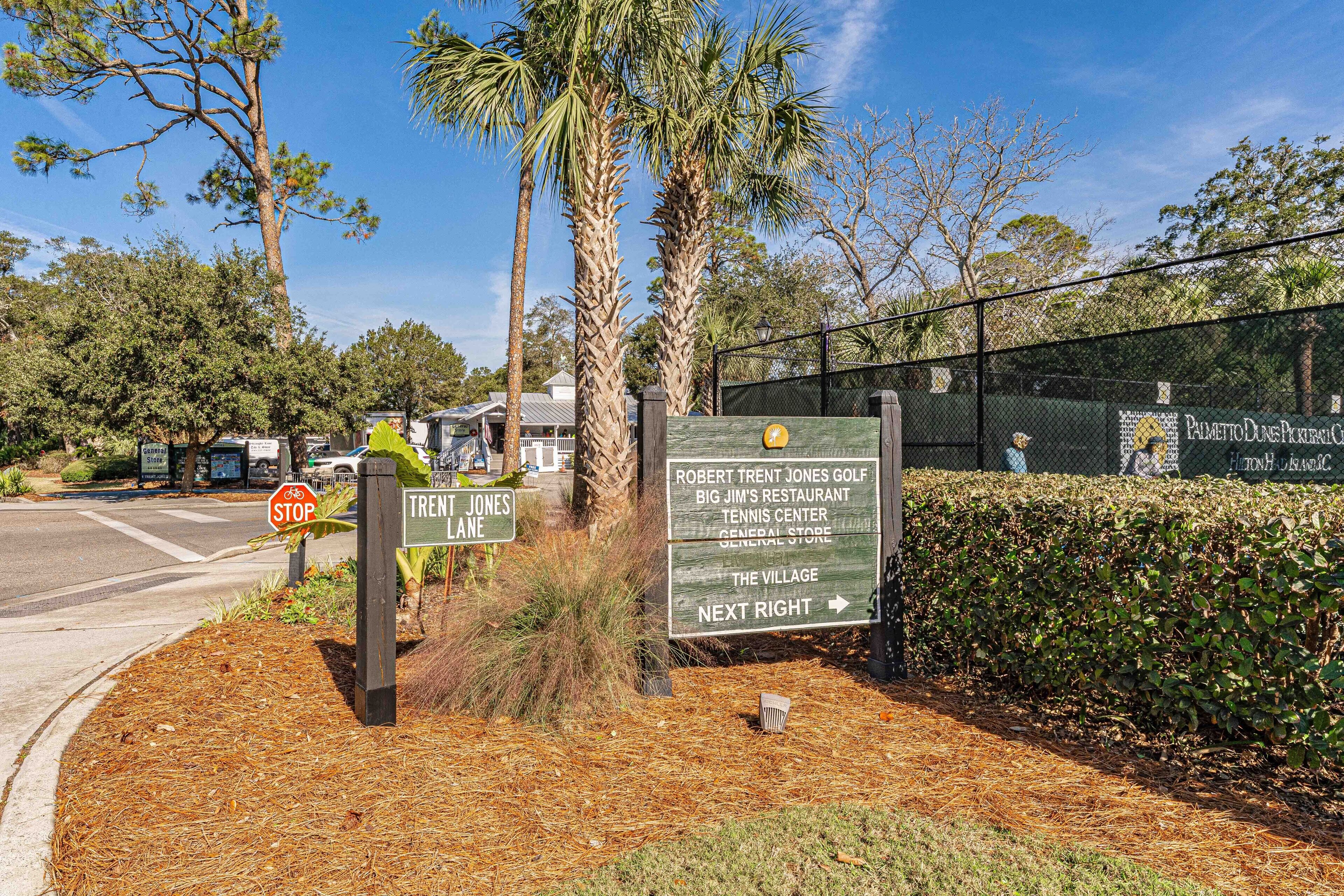 A signpost with directions to Robert Trent Jones Golf, Big Jim's Restaurant, Tennis Center, General Store, and The Village.