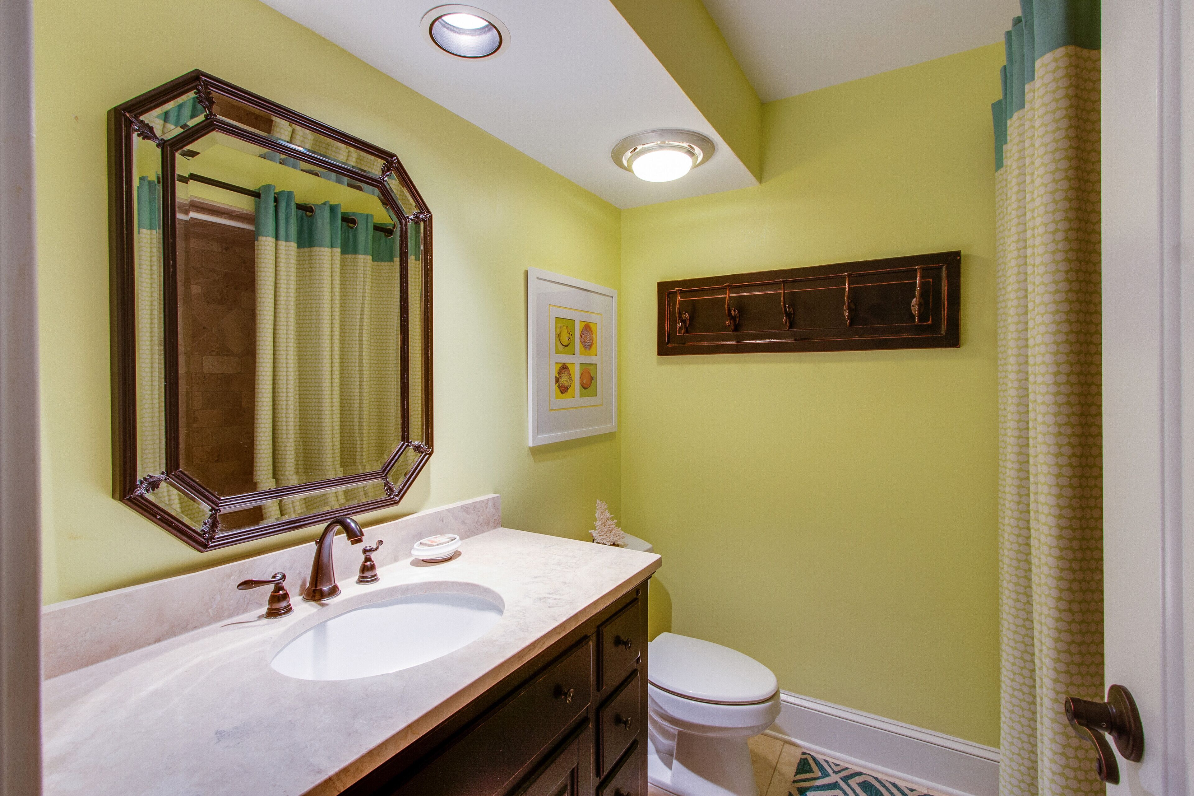 Une salle de bain avec un lavabo, un miroir et des toilettes.