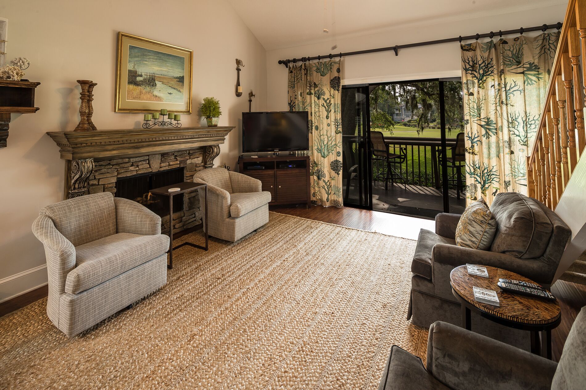 A living room with a fireplace, two sofas, a television, and a balcony with curtains.