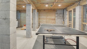 Enjoy a game of ping pong in this spacious room with a high ceiling and large windows.