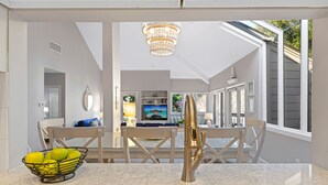Eine Küche mit Marmorarbeitsplatte, Spüle aus Edelstahl und einer Zitronenschale. Über der Spüle hängt eine Chandelier, und das Fenster bietet Blick ins Freie.
