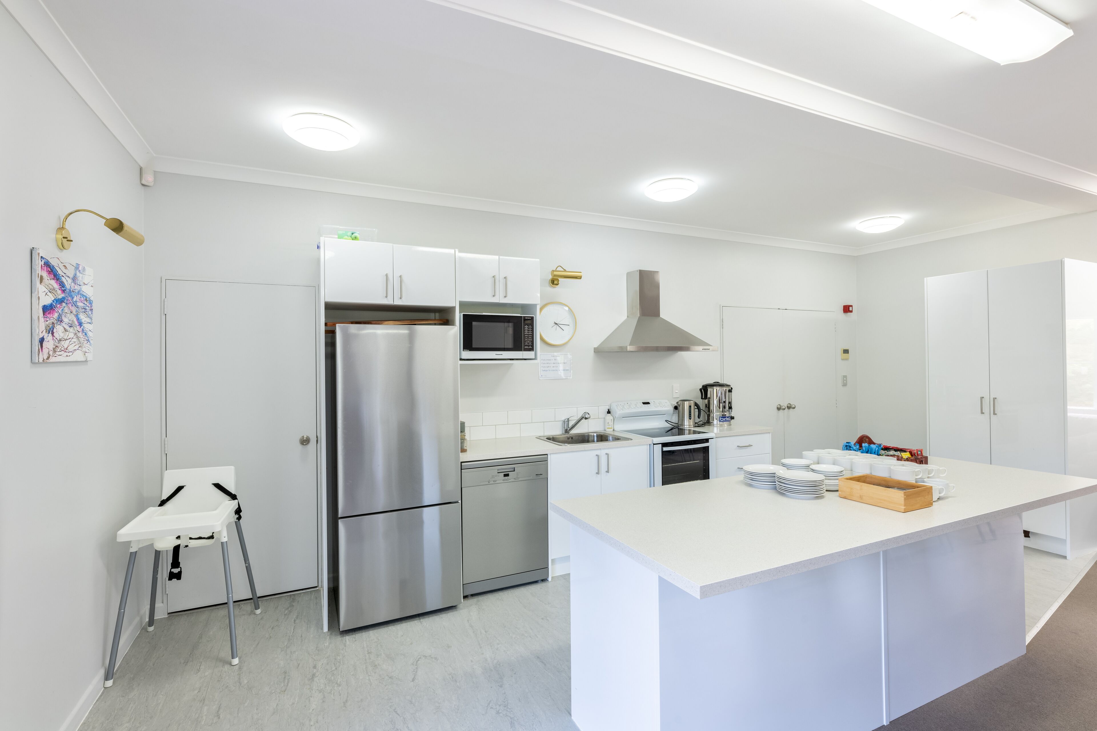 Een moderne keuken met witte kastjes, roestvrijstalen apparatuur en een centraal eiland.