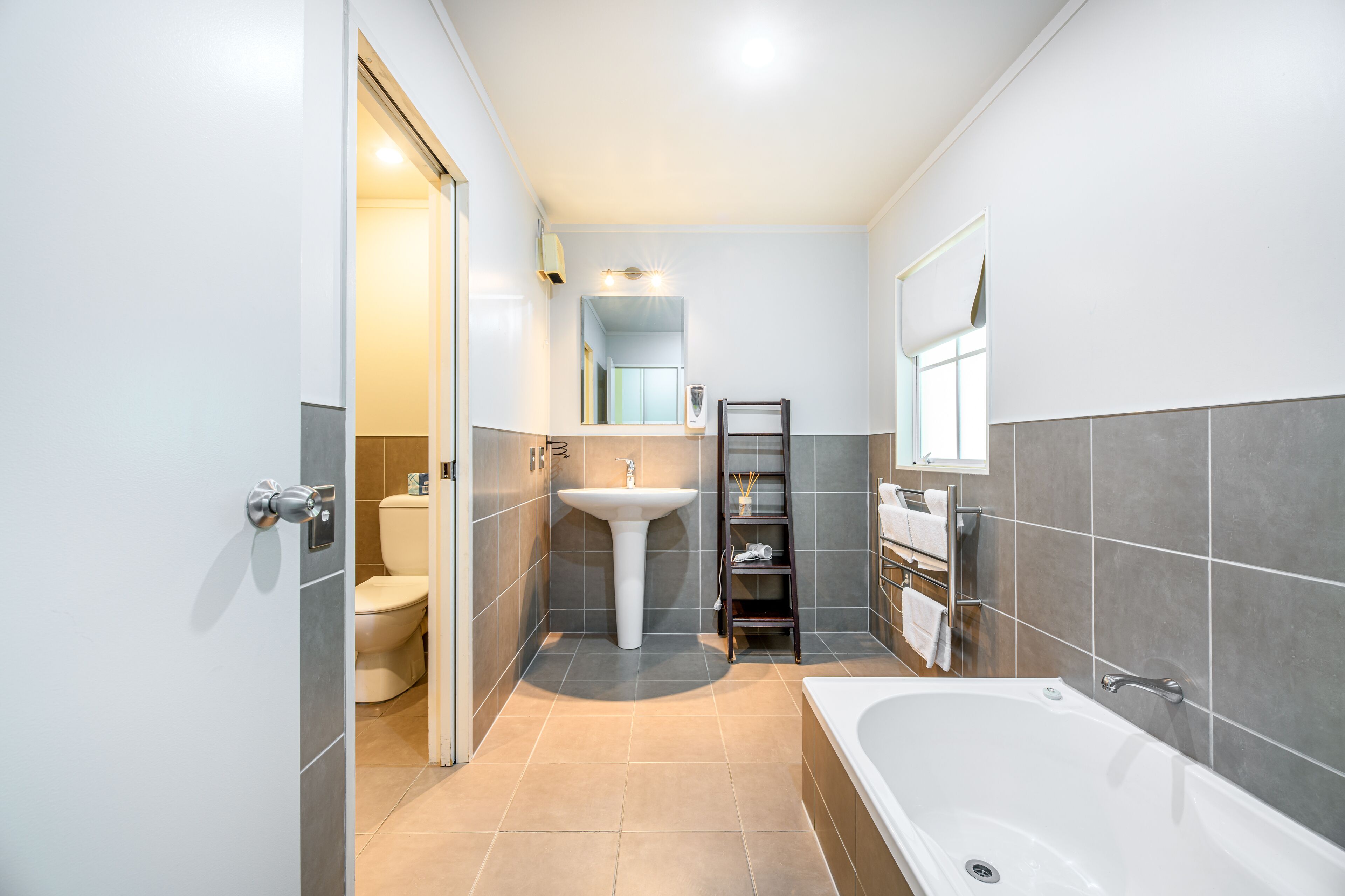 Une salle de bain moderne équipée de toilettes, d’un lavabo et d’une baignoire.