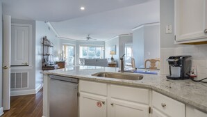 A kitchen with a central island, a built-in dishwasher, and a coffee maker.