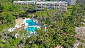 A resort with multiple buildings, a pool area, and surrounding greenery.