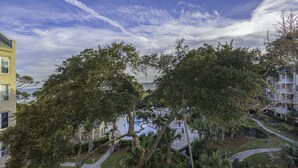 A residential area with a pool, pathways, and a view of the ocean.