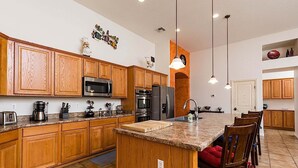 A modern kitchen with wooden cabinets, stainless steel appliances, and a granite countertop. - Westgate Wonder ~ A Resort-Style Oasis w/ Heated Pool, Spa, Game Rooms, Putting Green & More! (Glendale)