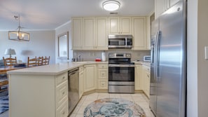 Enjoy cooking in this well-equipped kitchen with a central island, appliances, and a dining area nearby.