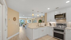 A modern kitchen with white cabinetry, a stainless steel microwave, and an oven. - Oceanfront Sea Cloisters Family 3BR Villa • Private Stairs to Beach, Pool & Boardwalk (Hilton Head Island)
