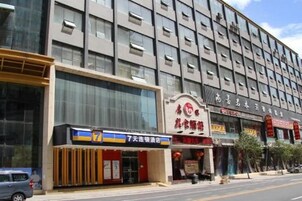 A multi-story building with a modern facade, featuring a prominent entrance with signage.