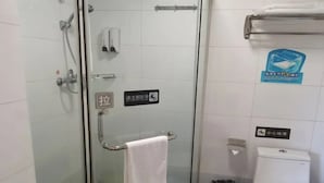 Un banyet petit amb plat de dutxa de vidre, un vàter blanc i un gresol.