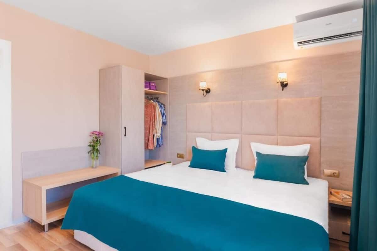 A bedroom with a bed, bedside tables, a wardrobe, and a bench.