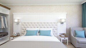 A hotel room with a large bed, two bedside tables, a chair, and a wardrobe. - Speranta Hotel&villas-all Incl and Private Beach (Balchik)