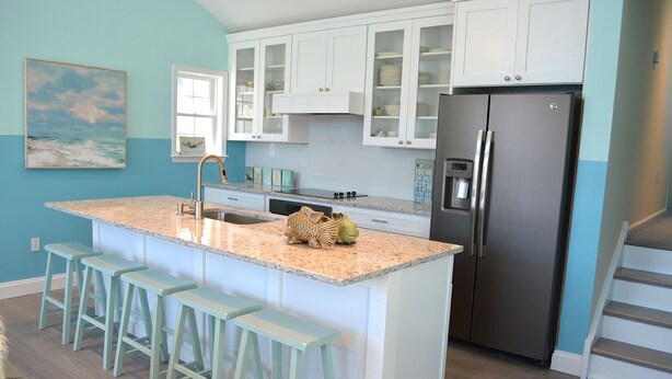 A kitchen with a central island, bar stools, a refrigerator, and cabinets. - Sleeps 10 - 3 bedroom, 2 bath, beach chairs, tags, very close to beach/boardwalk (Ocean City)