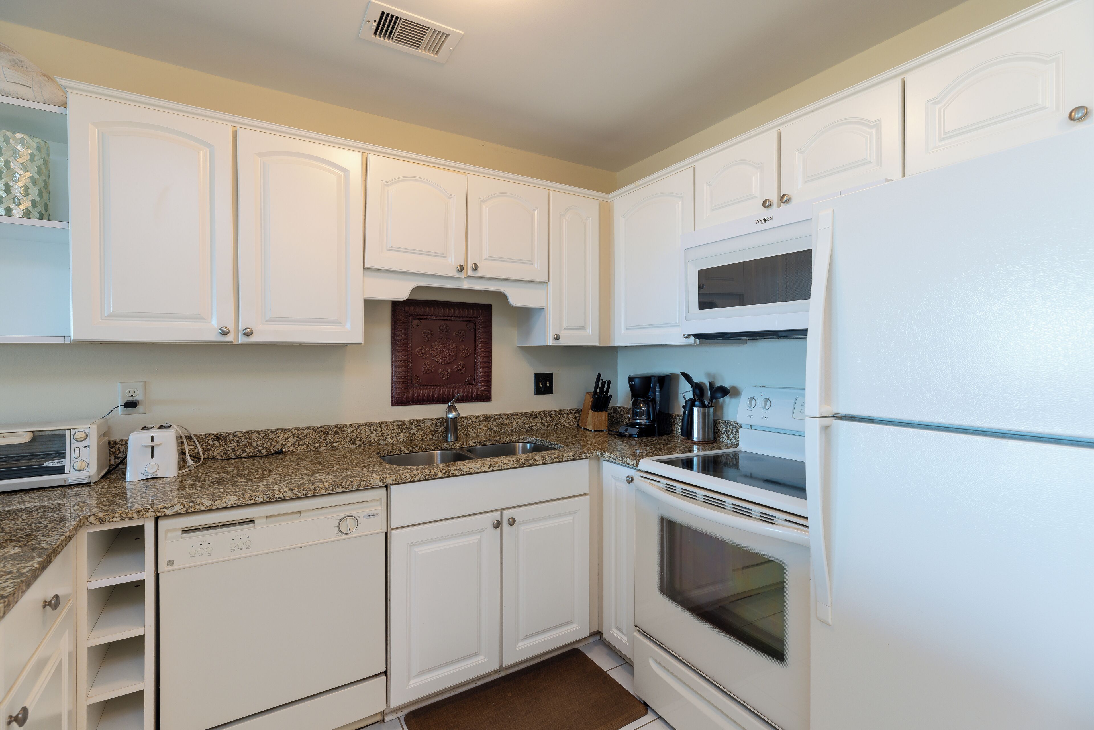 A kitchen with white cabinets, a microwave, a stove, and a dishwasher.