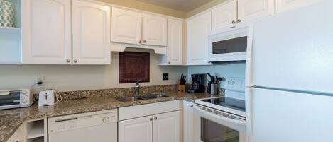A kitchen with white cabinets, a microwave, a stove, and a dishwasher.