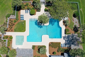 Relax by the resort's central pool surrounded by lush landscaping and shaded seating areas.