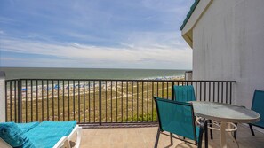 Enjoy breathtaking ocean views from this balcony with a table and chairs.