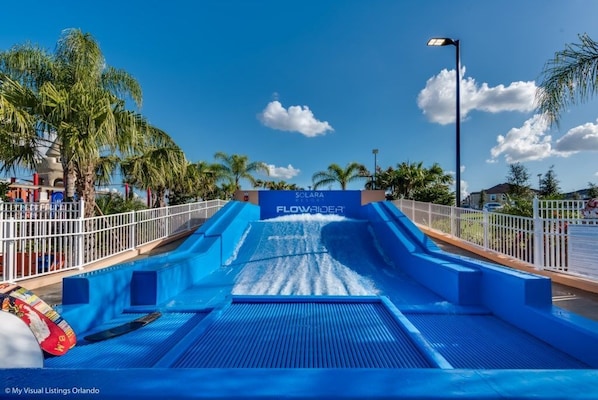 A water slide at Solana with a blue surface and a fence around it.