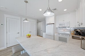 The open design flows seamlessly into the dining and living areas, making it easy to gather, cook, and enjoy time together by the coast.