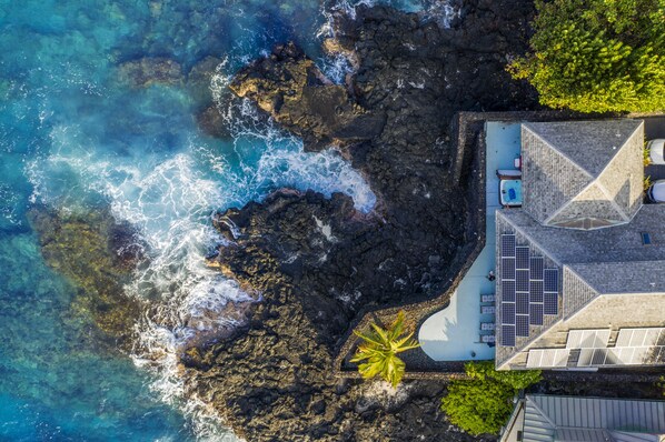 A resort with a pool, solar panels, and a view of the ocean.