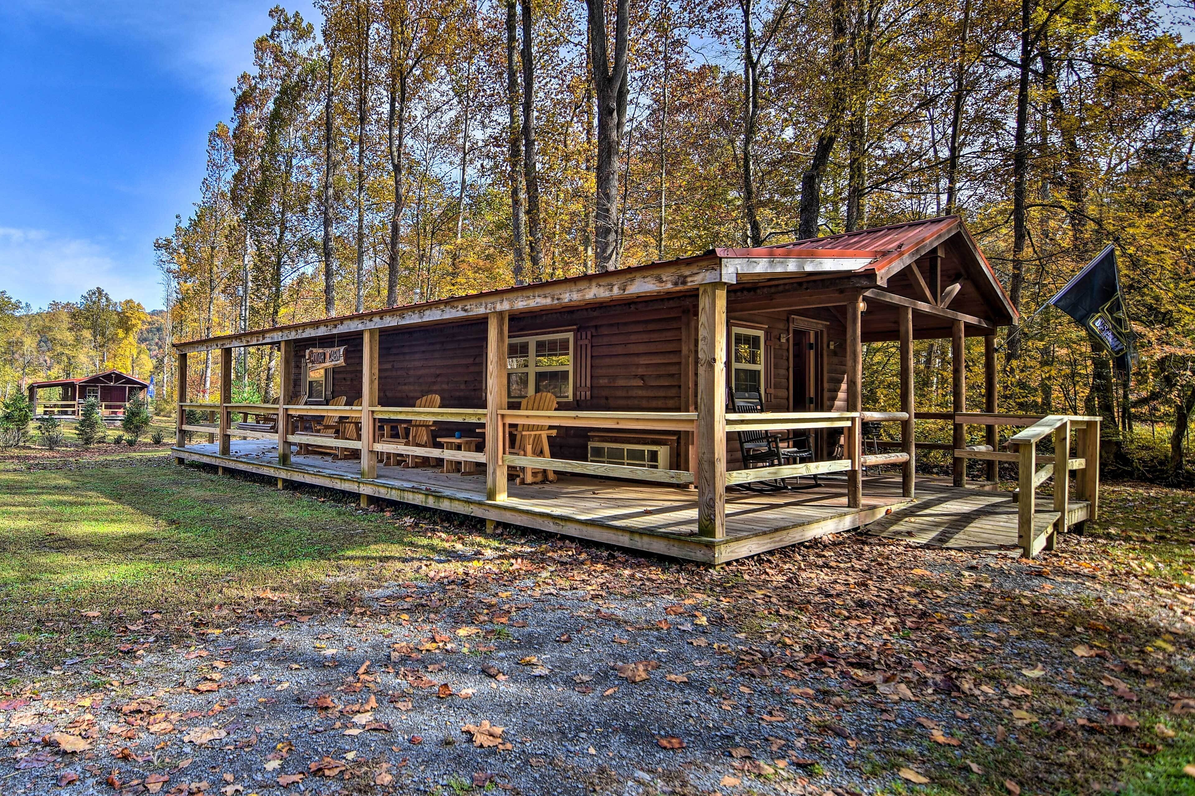 Une cabane en bois dotée d’un porche, de nombreuses fenêtres et d’une enseigne.