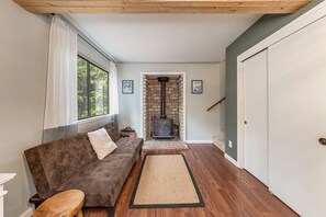 A cozy living room with a brown sofa, a wooden bench, a rug, and a fireplace. - LakeMont, wifi, GENERATOR, King bd, FREE Lake access +A/C (Arnold)
