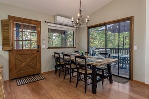A dining area with a wooden table and chairs, large windows, and a view of the outdoors. - LakeMont, wifi, GENERATOR, King bd, FREE Lake access +A/C (Arnold)