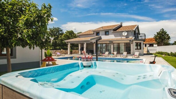 Ein modernes Haus mit Swimmingpool und Whirlpool.